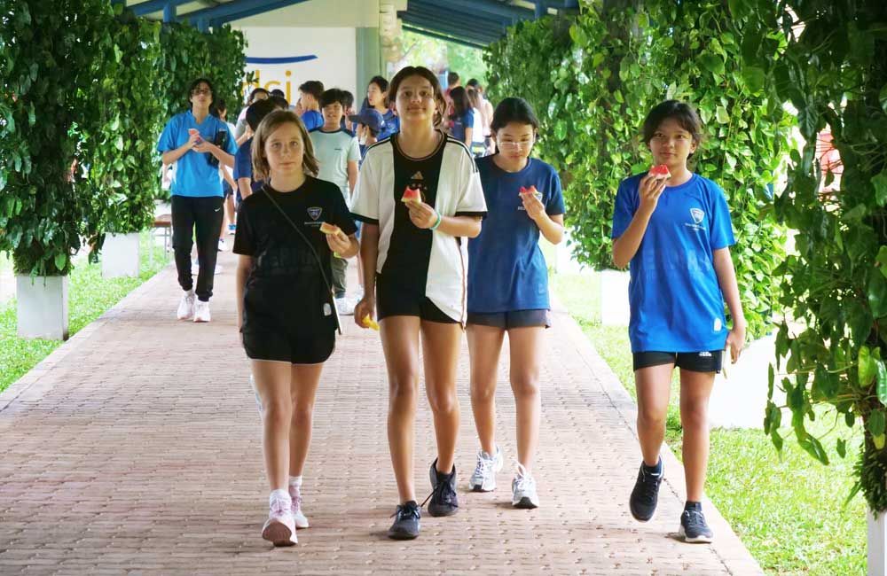 A group of young girls are walking down a brick walkway.