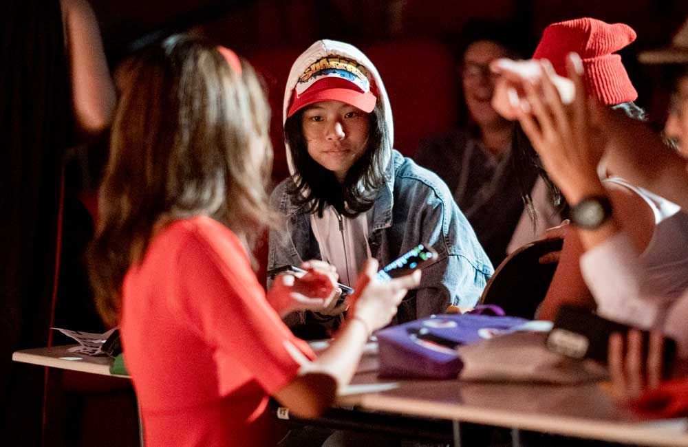 A group of people are sitting at a table talking to each other.