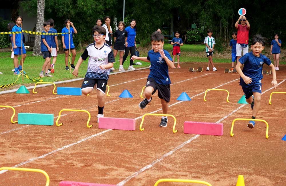 A group of young boys are running a race on a track.