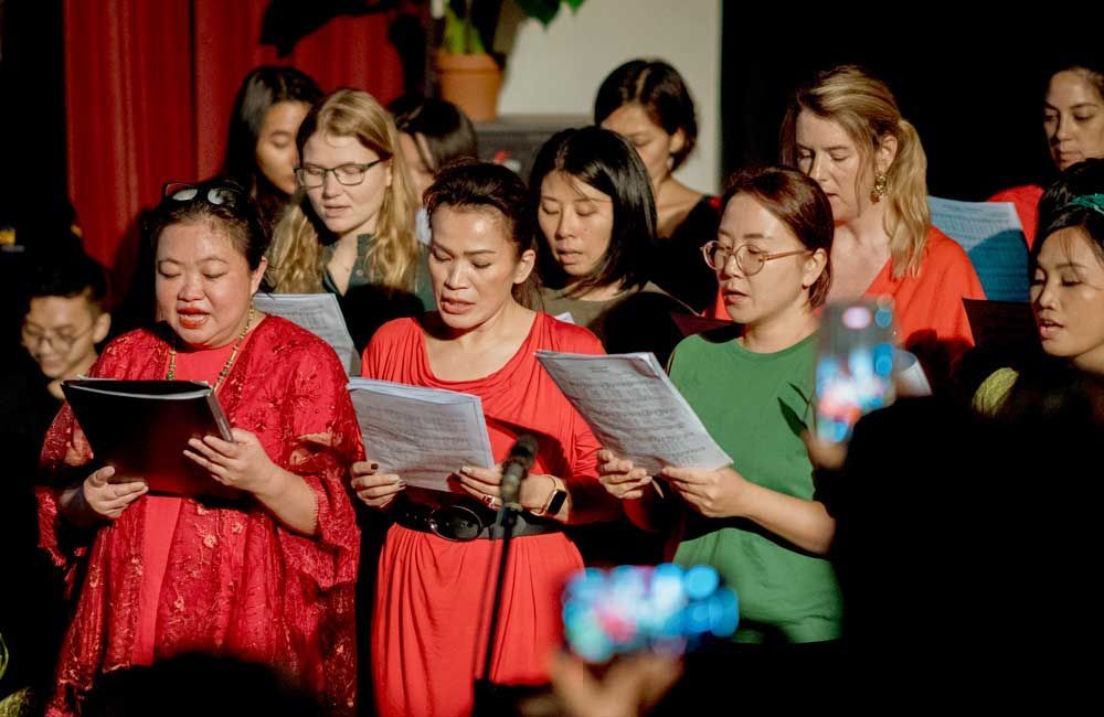 A group of women are singing together in a choir.