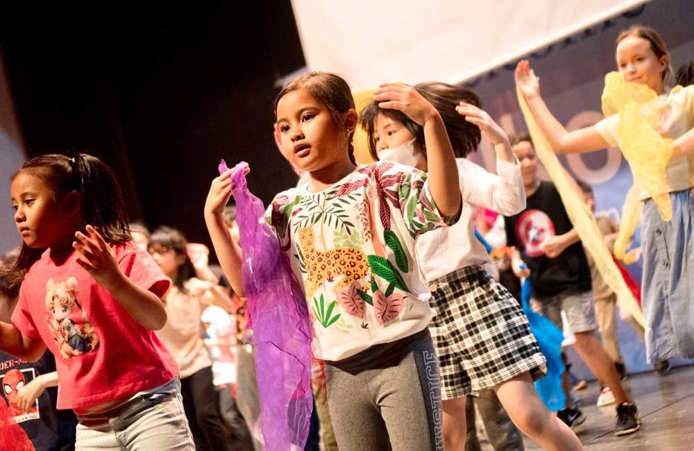 A group of children are dancing on a stage.