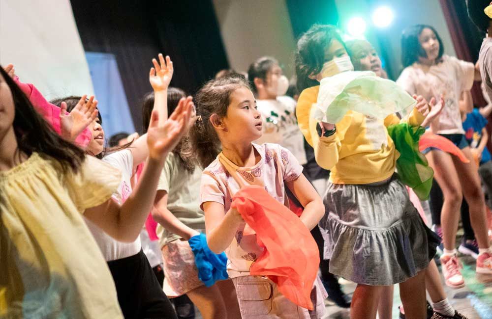 A group of young girls are dancing on a stage.