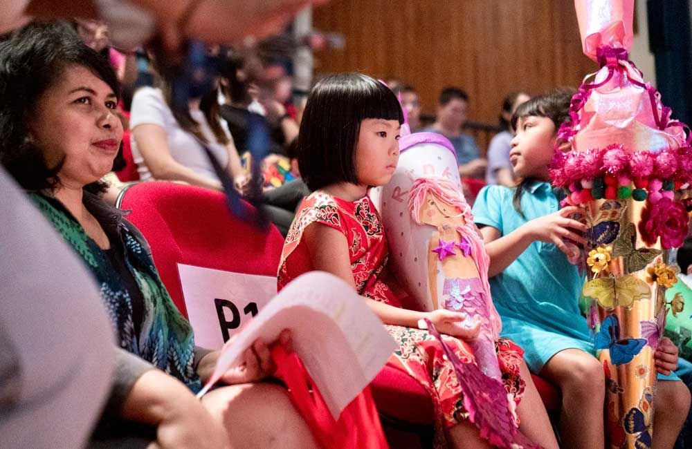 A group of people are sitting in a theater watching a performance.