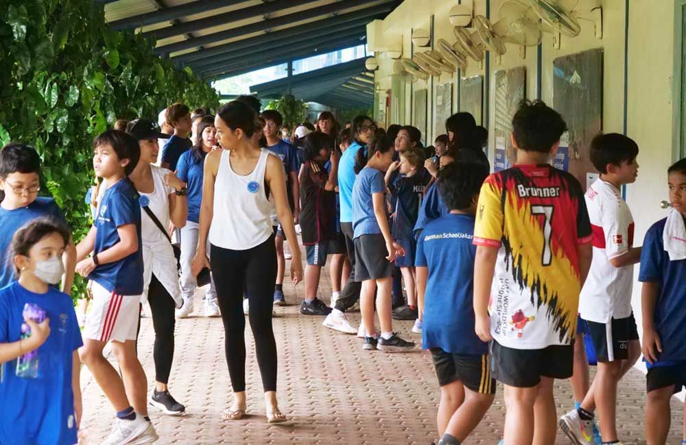 A group of children are standing outside of a building.