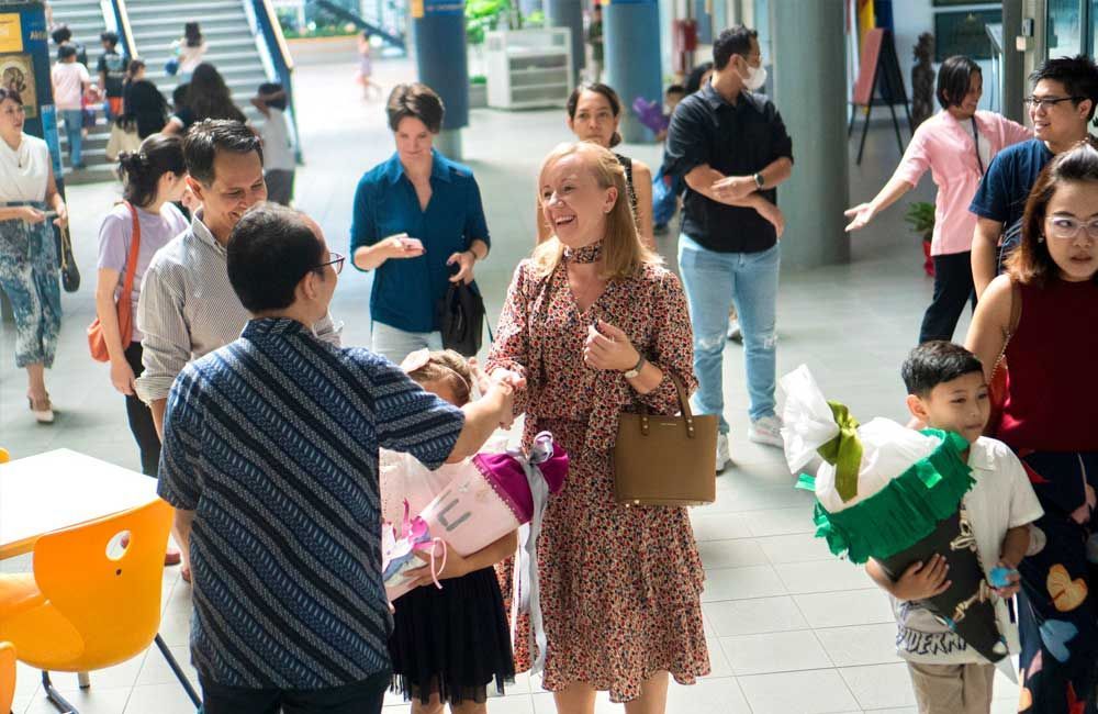 A group of people are standing in a hallway talking to each other.