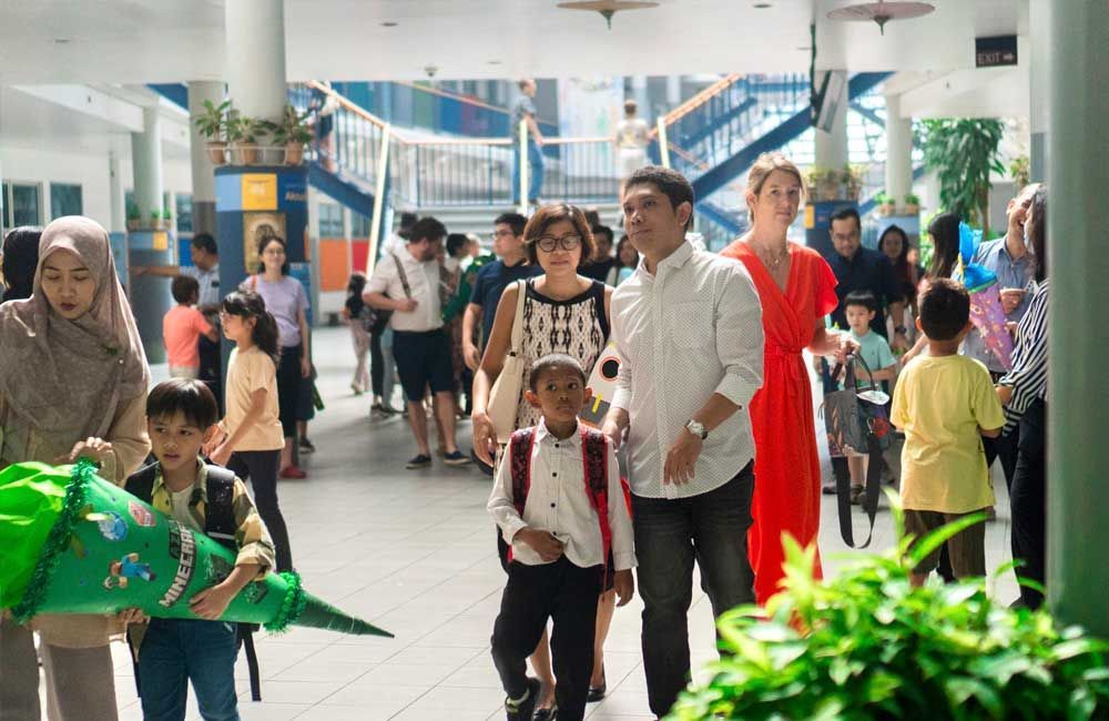 A group of people are walking down a hallway in a school.
