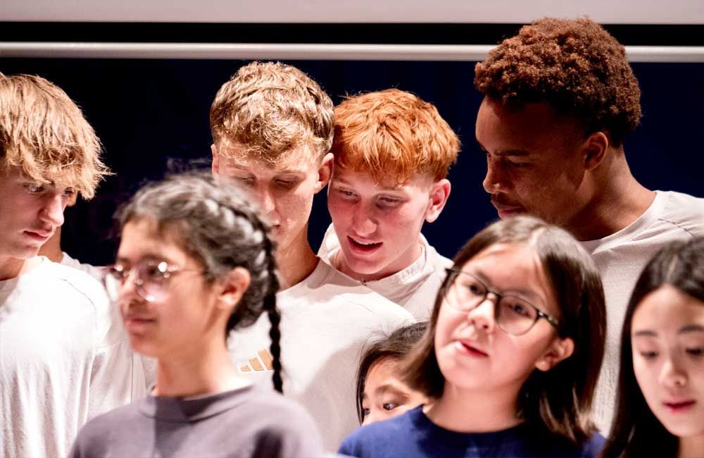 A group of young people are standing next to each other in a room.