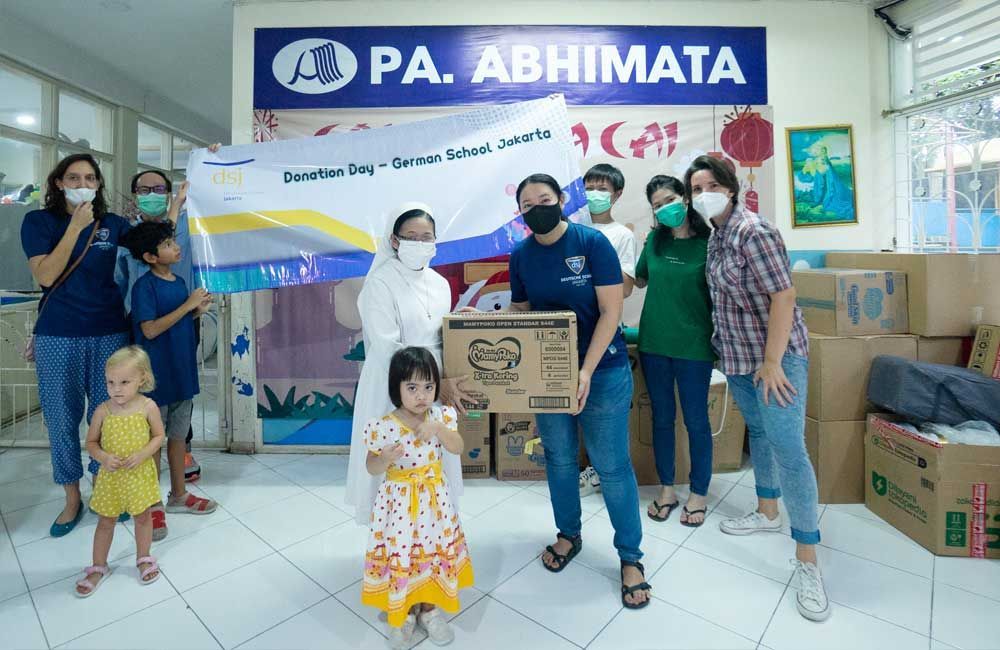 A group of people wearing face masks are standing in a room.