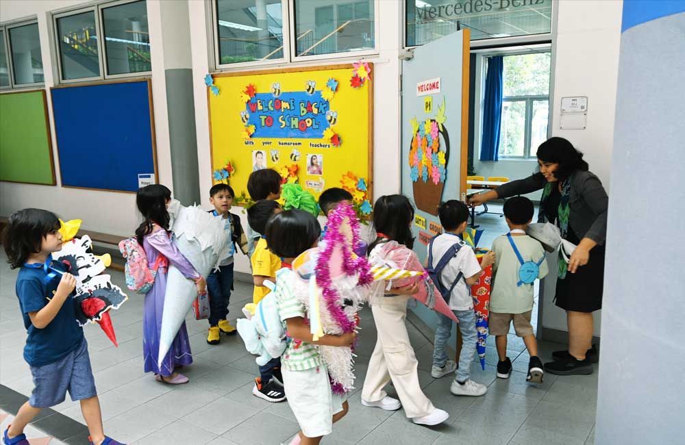 A group of children are walking through a hallway in a school.
