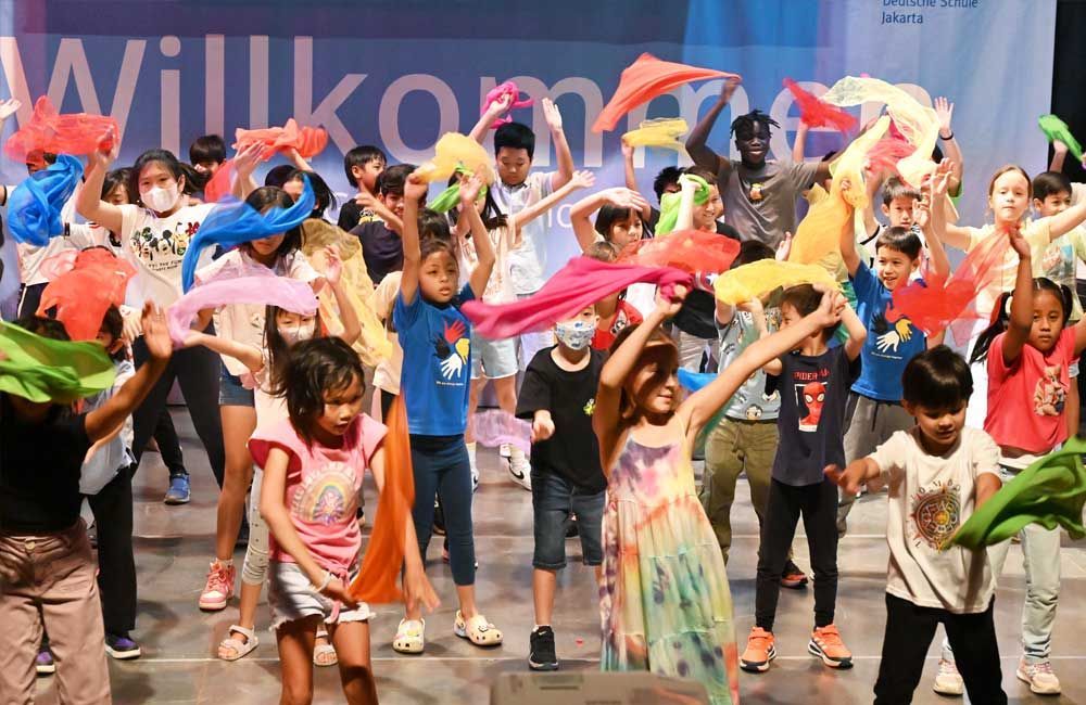 A group of children are dancing on a stage.