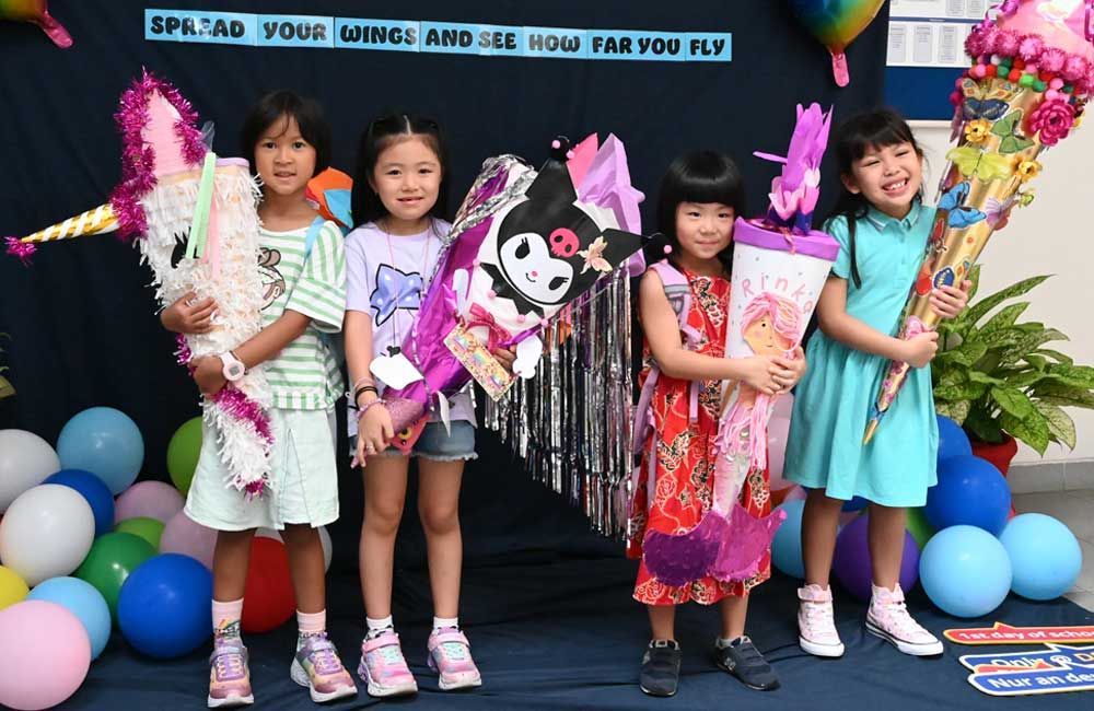 A group of young girls are posing for a picture in front of balloons