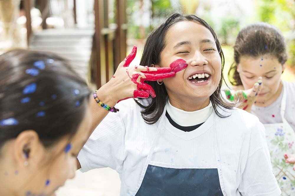 Curly hair student holding books in front of university
