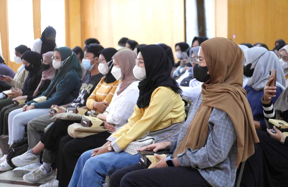 A group of people wearing face masks are sitting in a room.