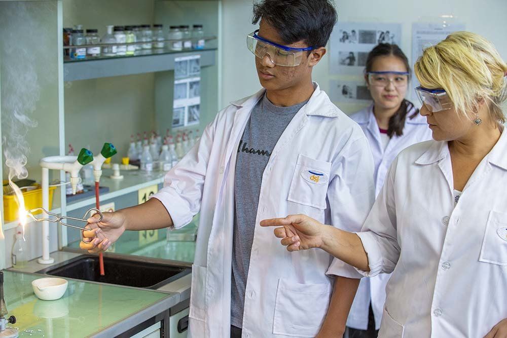 Secondary students and their teacher during a science experiment at the German School Jakarta chemical lab