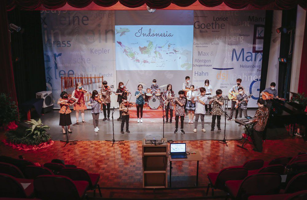 The Deutsche Schule Jakarta Orchestra performs on stage