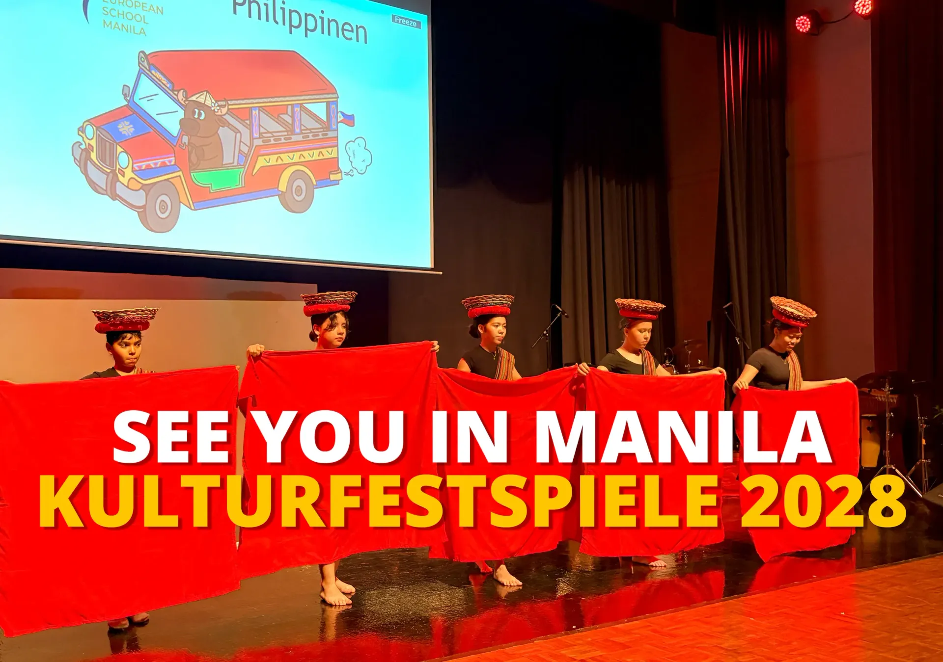 Performers in red on stage under a screen reading “See You in Manila Kulturfestspiele 2028”