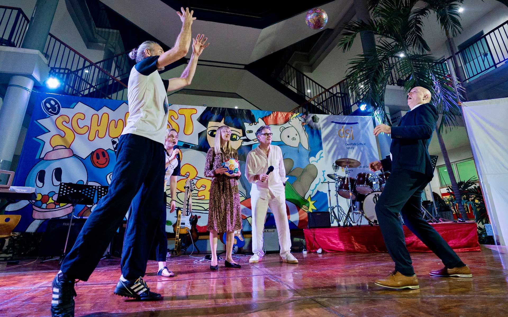 A group of people are playing basketball on a stage.