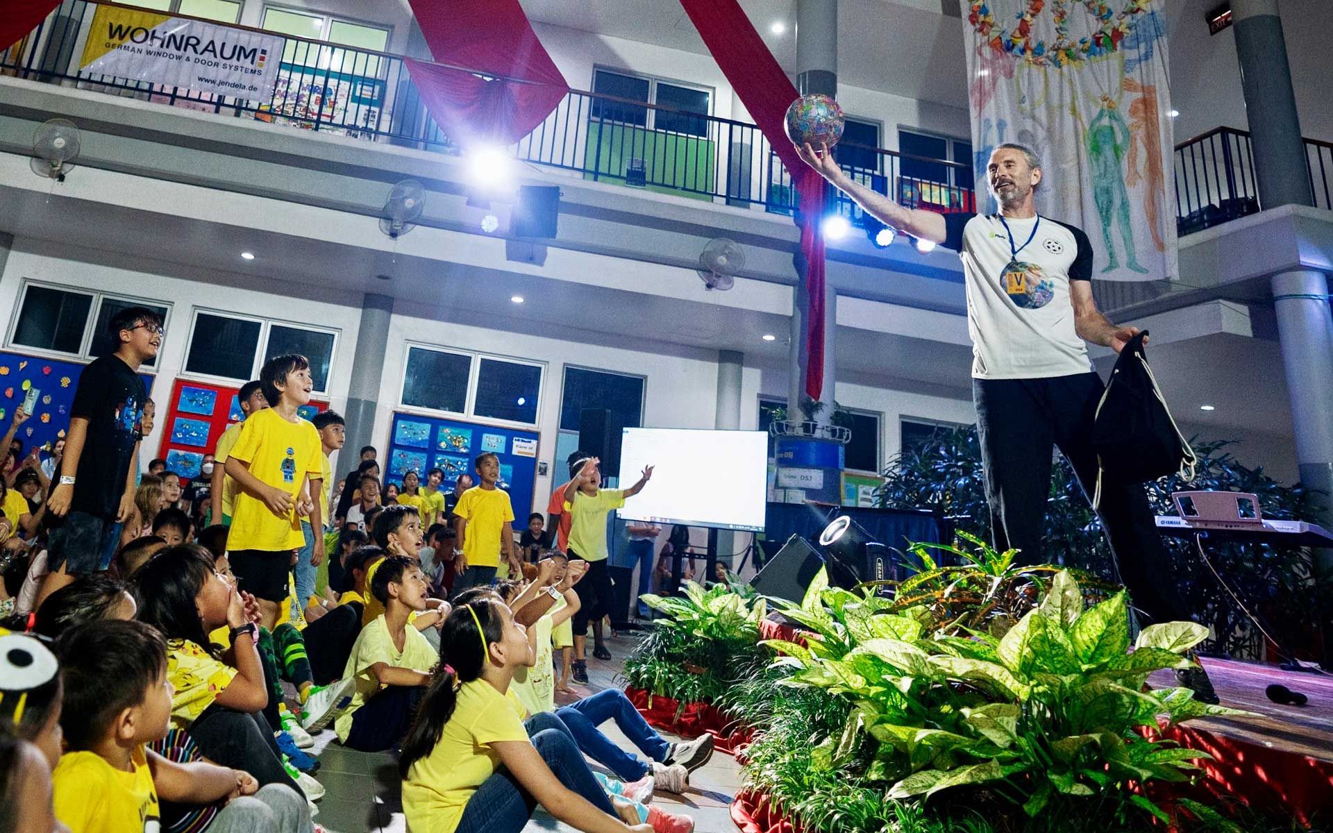 A man is standing in front of a crowd of people holding a torch.