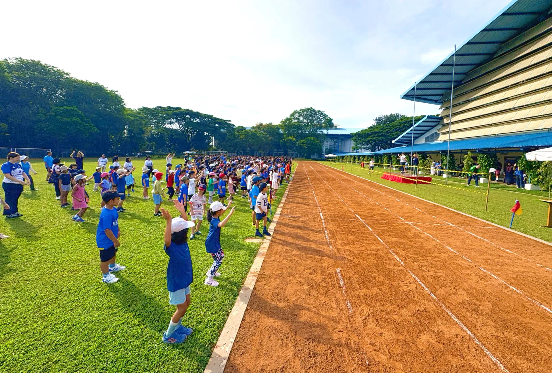 A group of children are running on a dirt track.