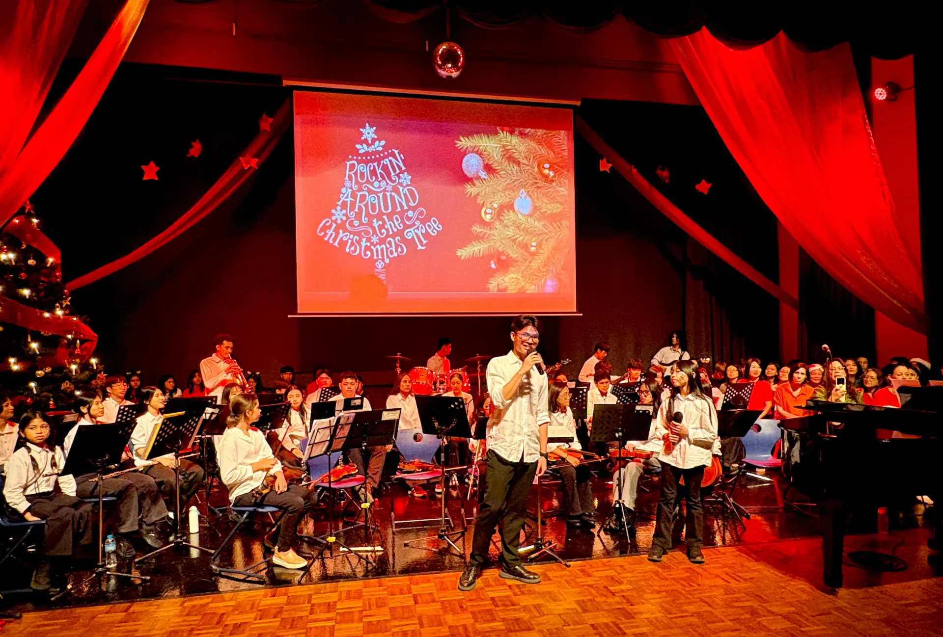 a large crows of people are gathered at a German school christmas party