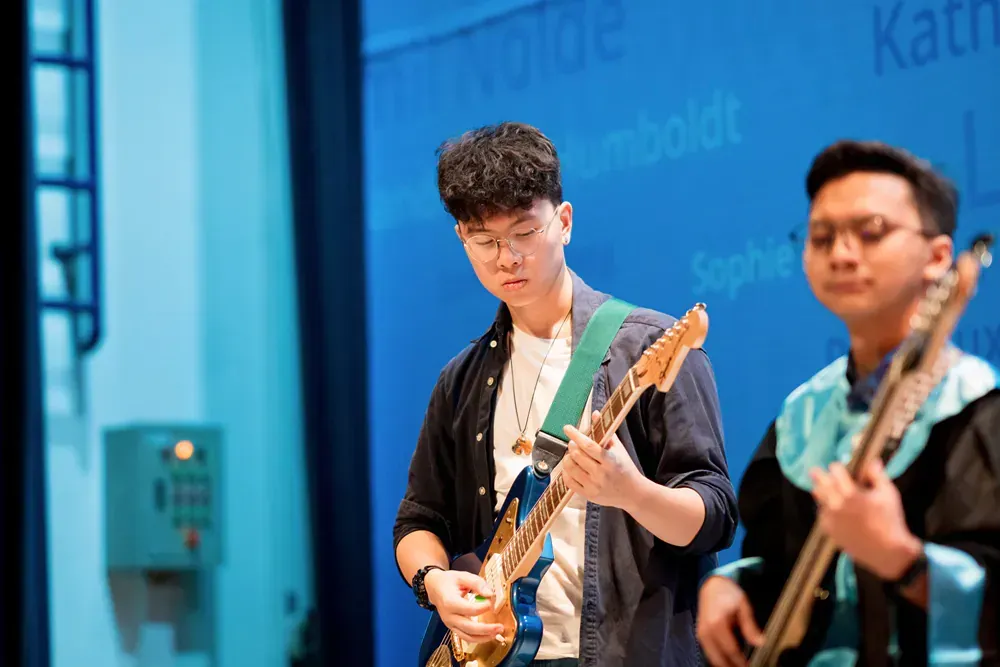 Two men are playing guitars on a stage.