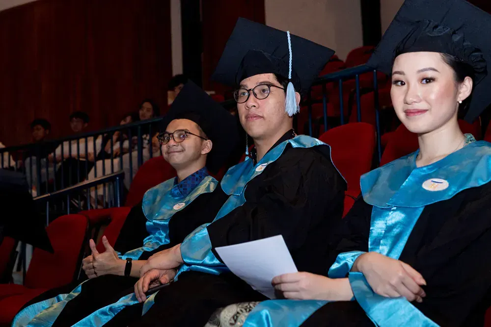 A group of graduates are sitting in a theater.