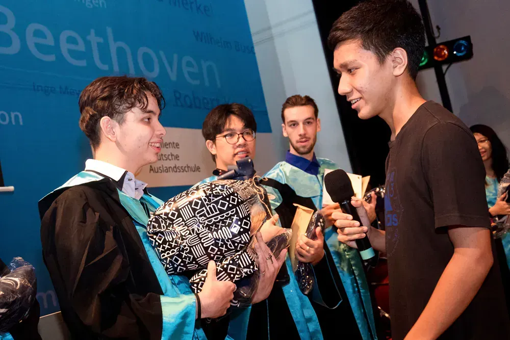 A group of people are standing in front of a sign that says beethoven