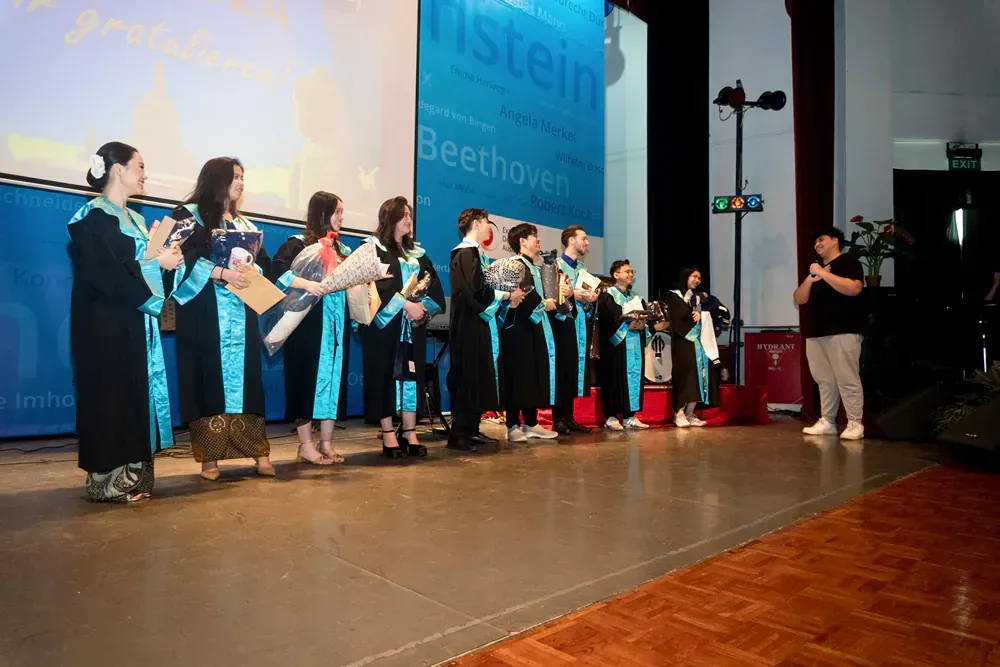 A group of people standing on a stage in front of a sign that says beethoven