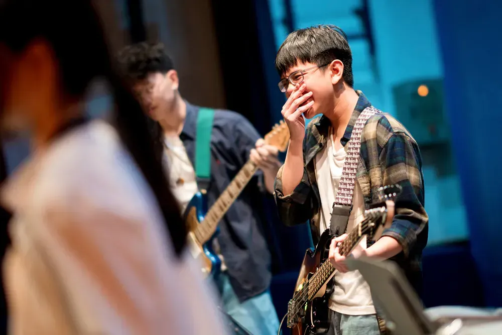 A group of young men are playing guitars on a stage.