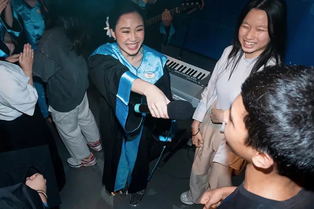 A group of people are dancing in a room with a piano in the background
