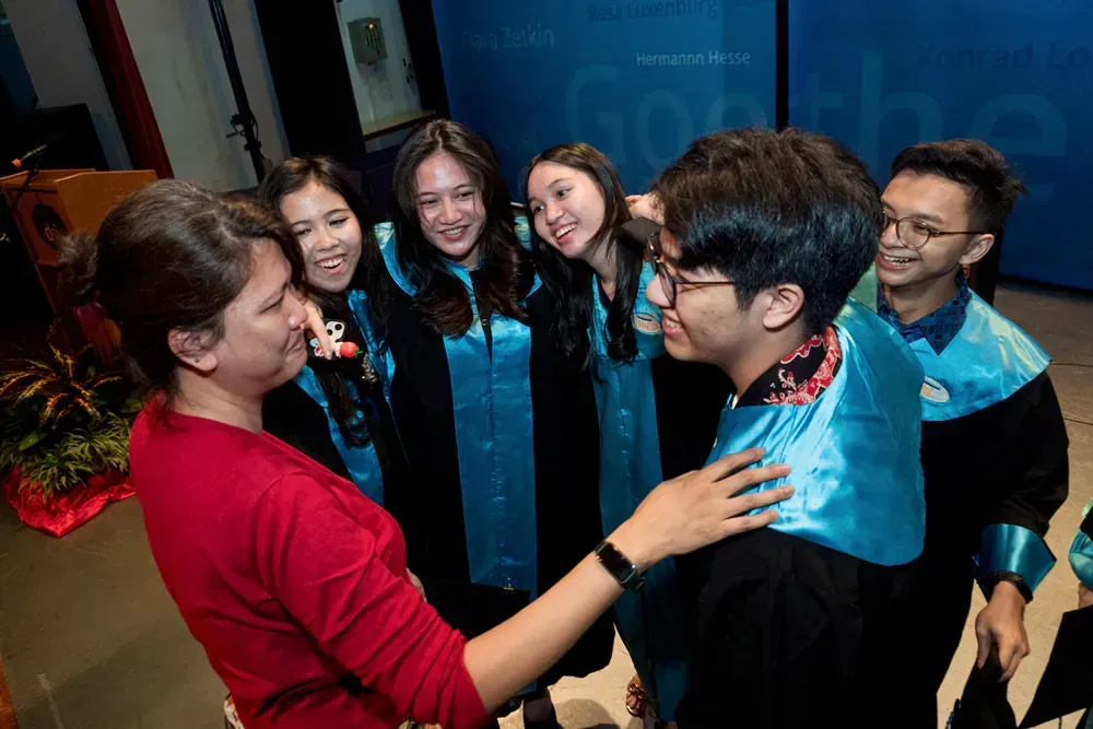 A group of people are standing around a man in a graduation cap and gown.