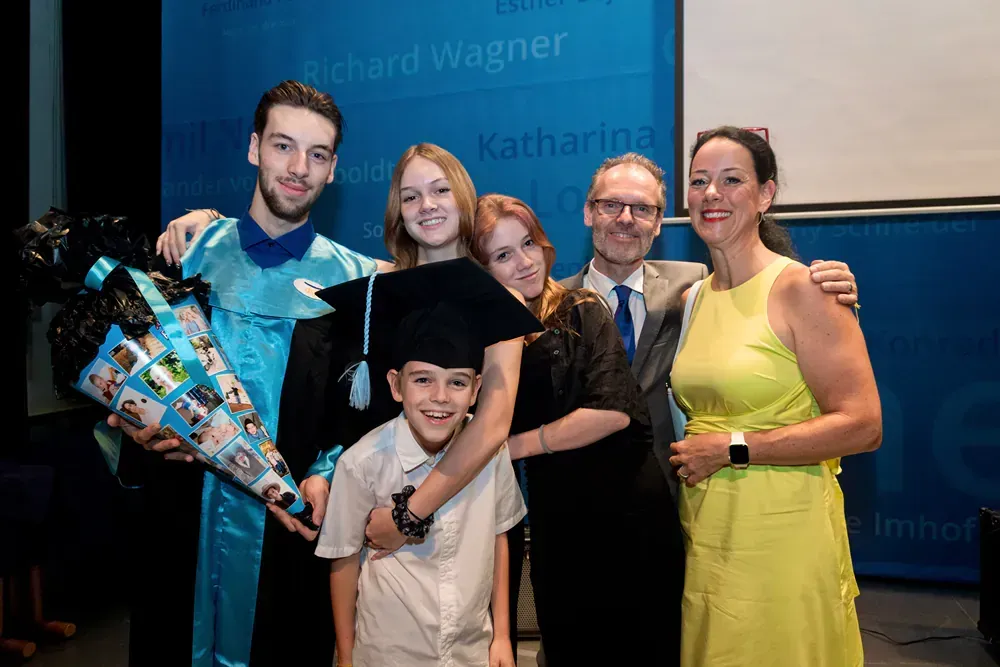 A group of people are posing for a picture at a graduation ceremony.