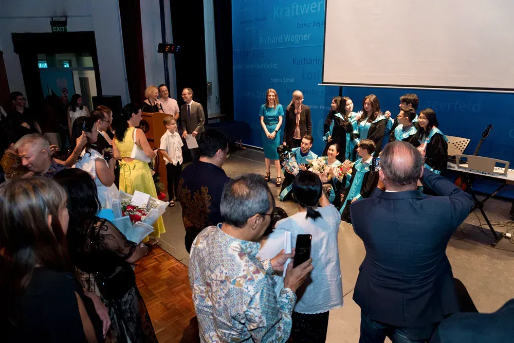 A group of people are standing in front of a projector screen.
