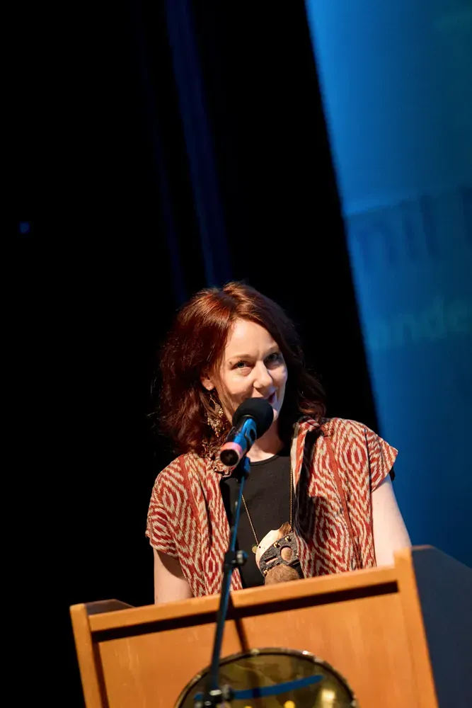 A woman is speaking into a microphone at a podium