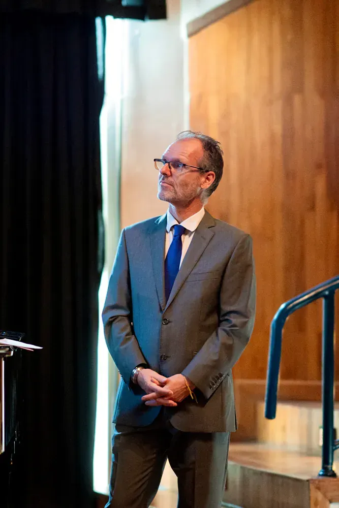 A man in a suit and tie is standing in front of a podium.