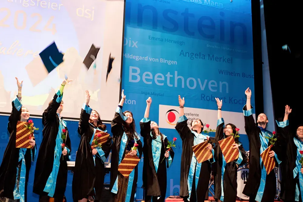 A group of graduates are throwing their caps in the air
