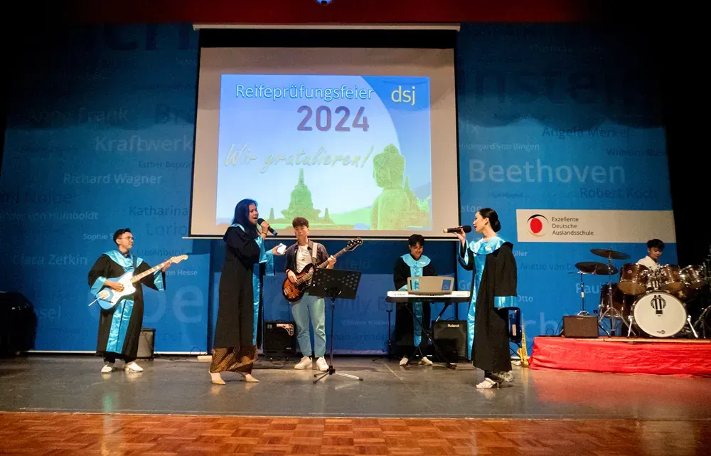 A group of people are standing on a stage playing instruments.