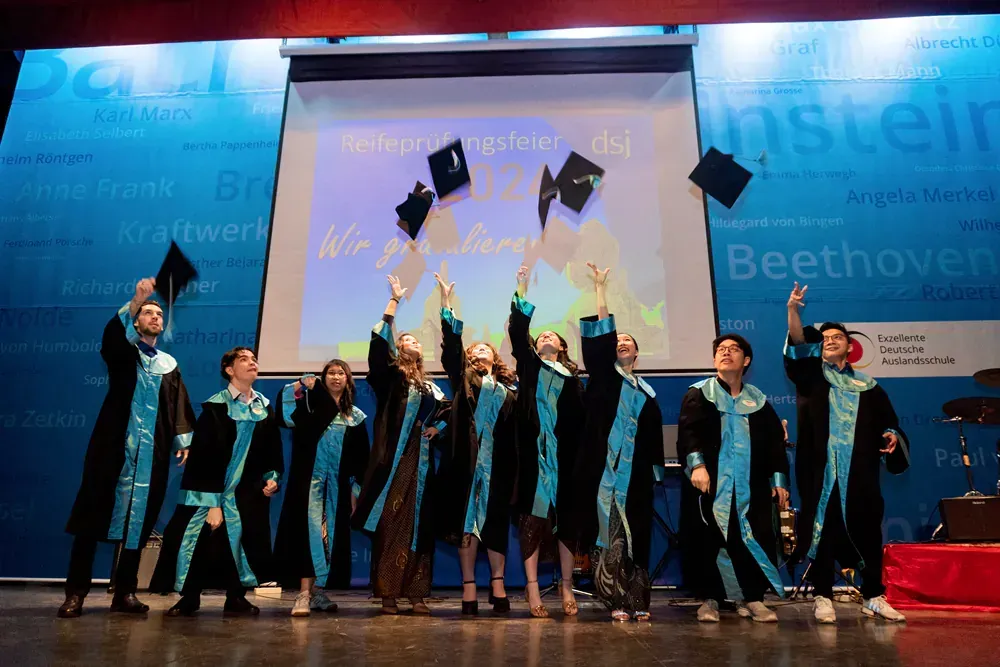A group of graduates are throwing their caps in the air
