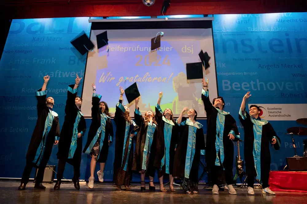 A group of graduates are throwing their caps in the air.