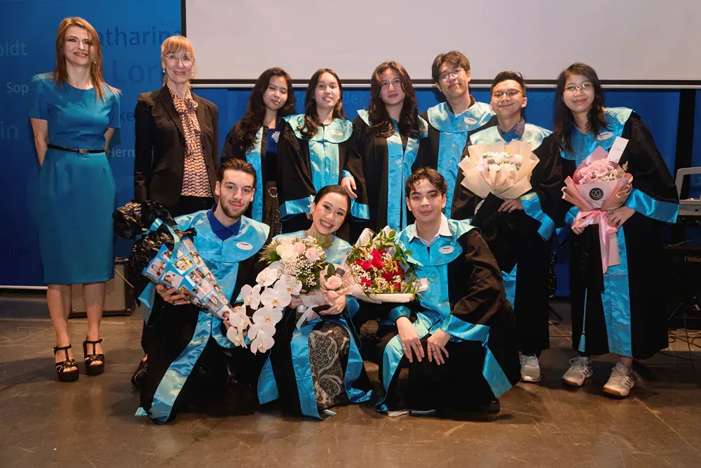 A group of people in graduation gowns are posing for a picture.