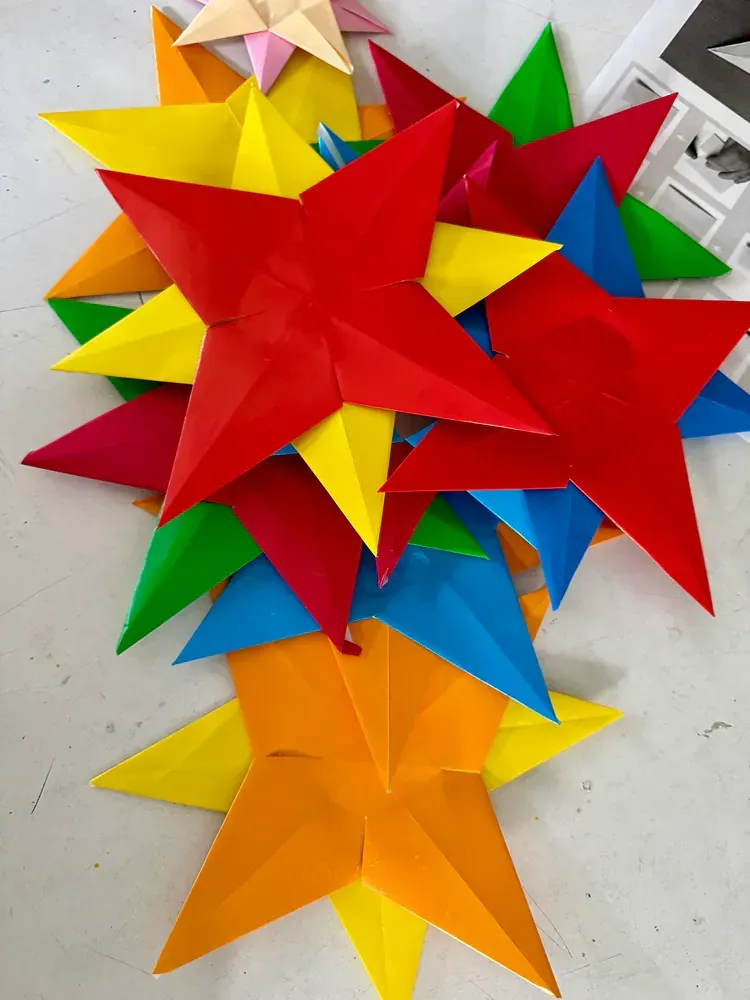 A bunch of colorful paper stars are stacked on top of each other