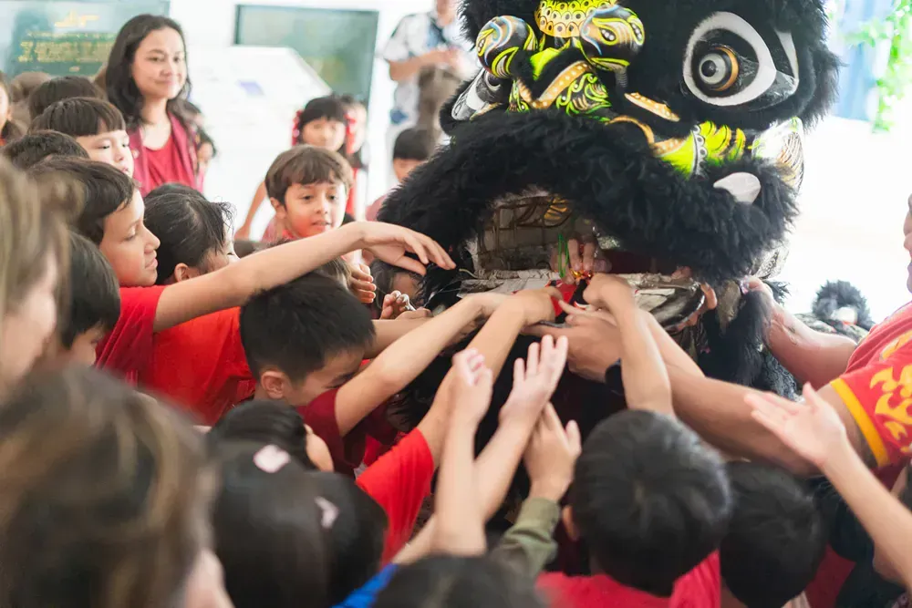 A group of children are reaching for a lion costume.