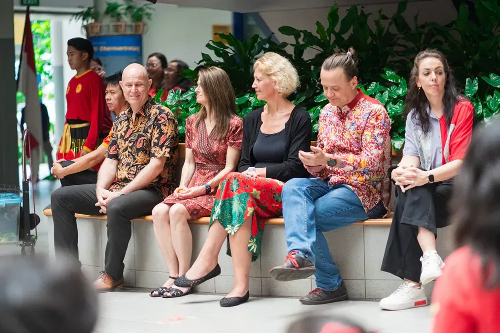 A group of people are sitting on a bench.
