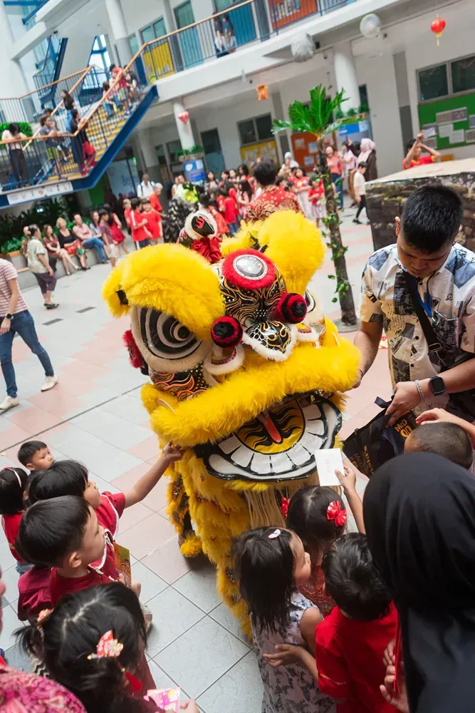 A group of children are playing with a lion costume.
