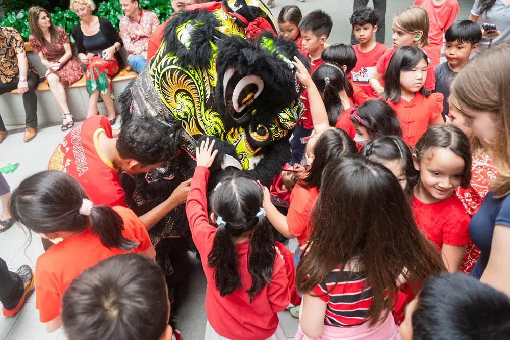 A group of children are playing with a lion.