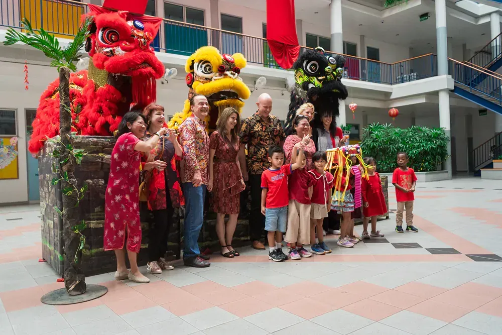 A group of people are posing for a picture in front of a lion costume.