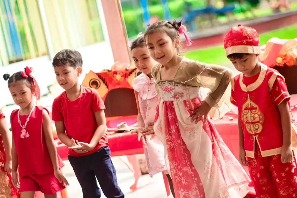 A group of children dressed in traditional chinese costumes are standing next to each other.