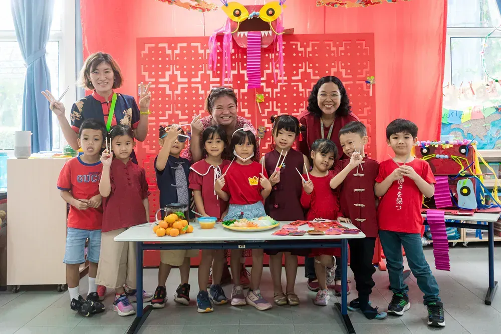 A group of children are posing for a picture in front of a table.