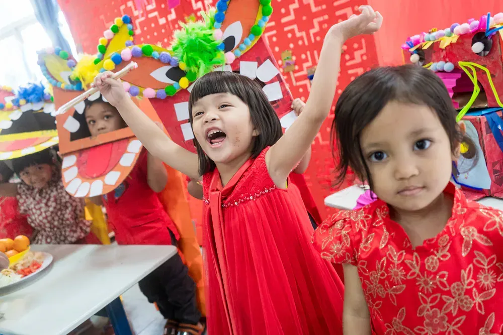 A group of young girls are standing next to each other in a room.