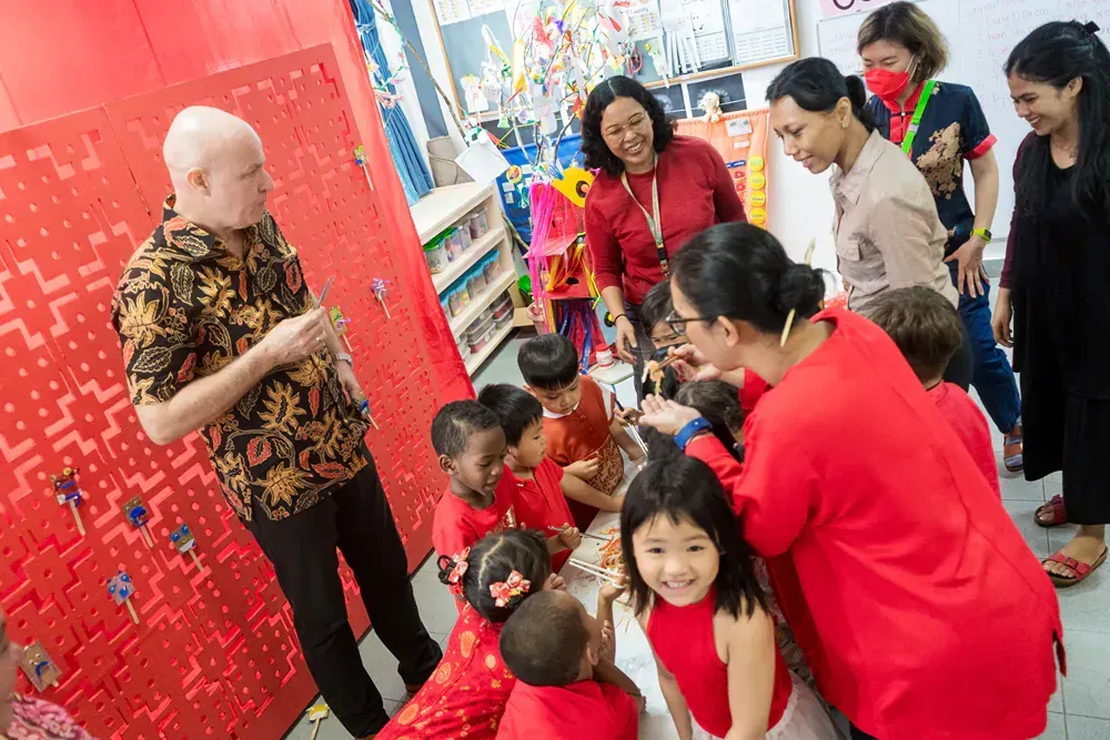 A group of people are standing around a table with children.